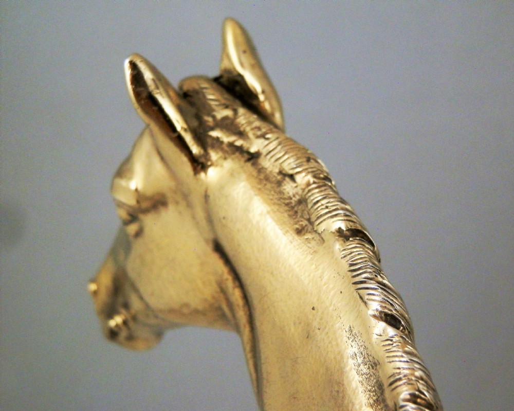 A side-profile view of a gold-coloured silver gilt sculpture depicting a standing racehorse with a detailed mane and muscular structure. View XIII