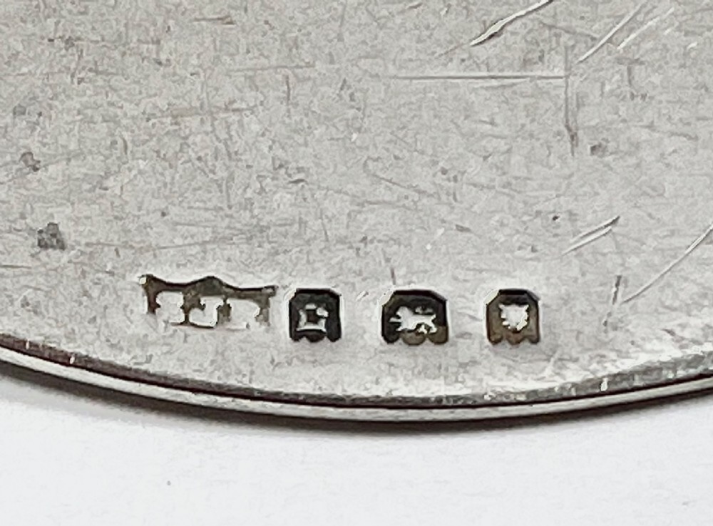 An oval sterling silver decanter label engraved with the word SHERRY and an engine-turned border pattern, suspended from a silver chain. View IV