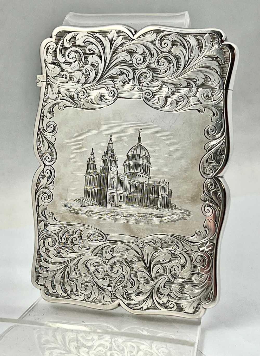 An engraved sterling silver card case featuring a central depiction of St Pauls Cathedral framed by intricate scrollwork.