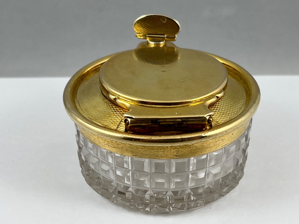 A circular George IV cut glass travelling inkwell with an engine-turned silver gilt lid and latch mechanism. View II