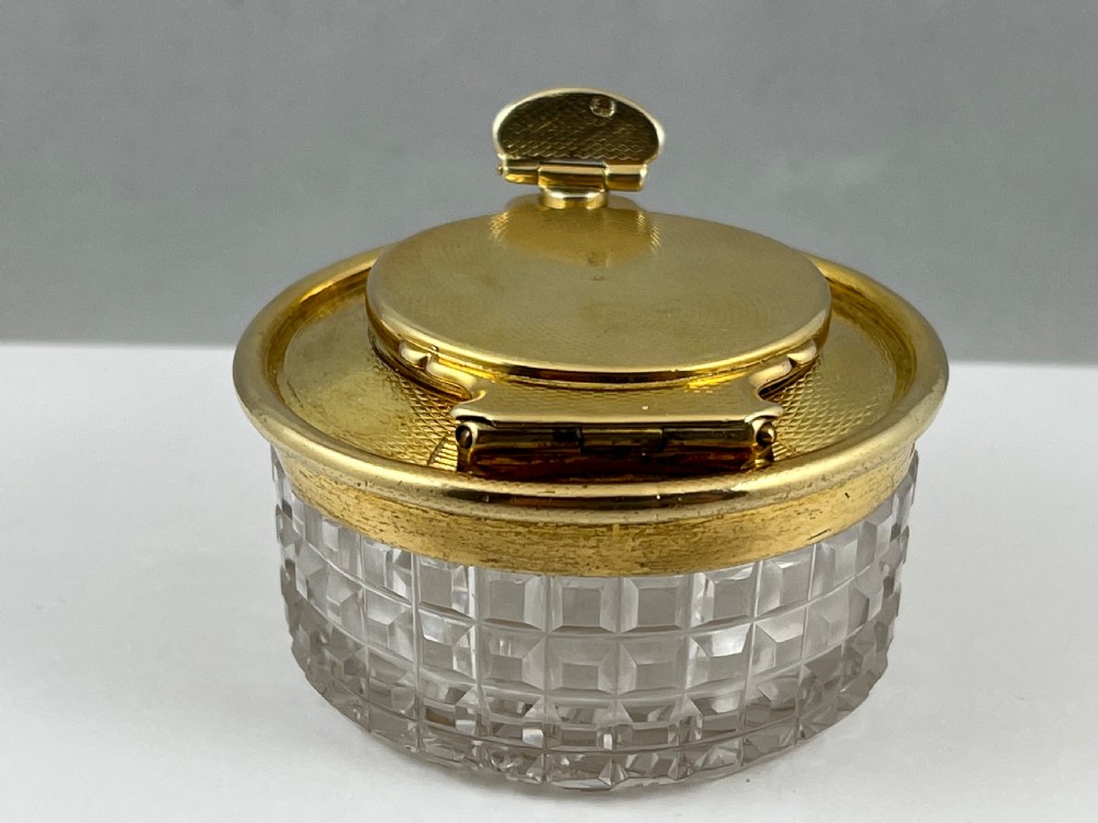 A circular George IV cut glass travelling inkwell with an engine-turned silver gilt lid and latch mechanism. View X