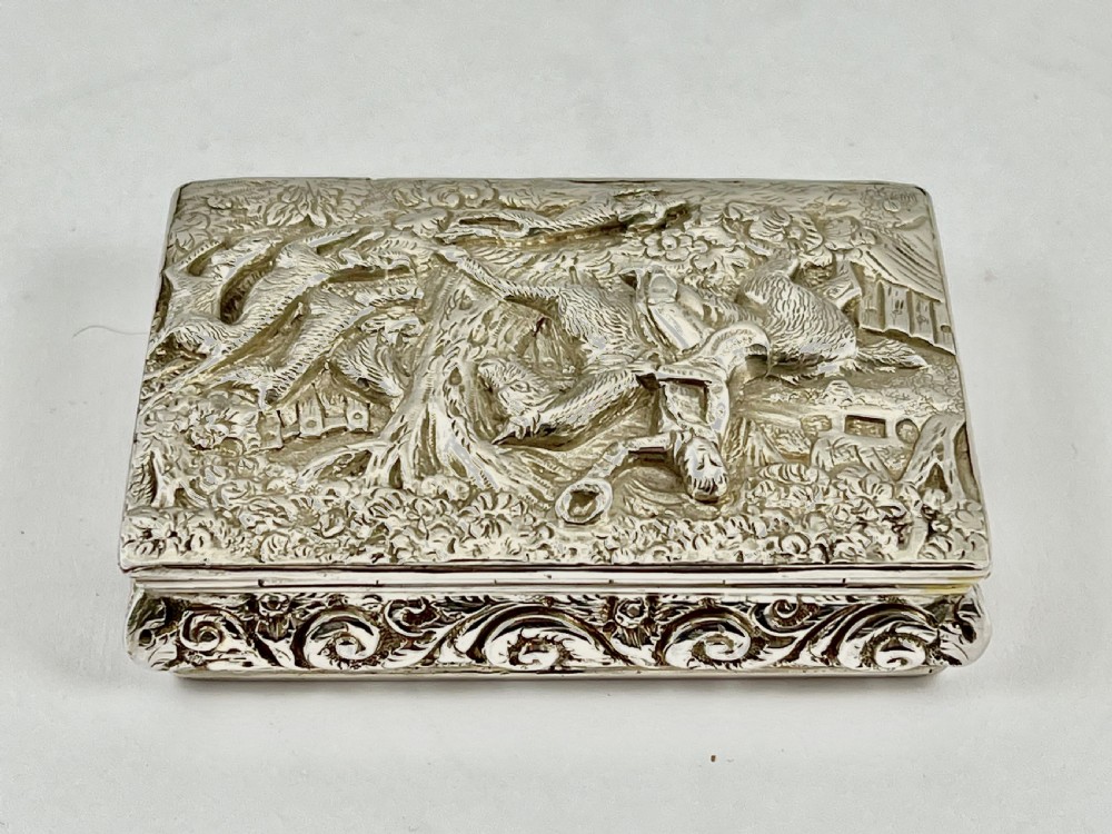 Rectangular sterling silver snuff box featuring a relief-carved hunting scene with a rider on horseback surrounded by hounds in a woodland setting. View III
