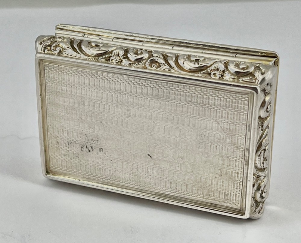 Rectangular sterling silver snuff box featuring a relief-carved hunting scene with a rider on horseback surrounded by hounds in a woodland setting. View V