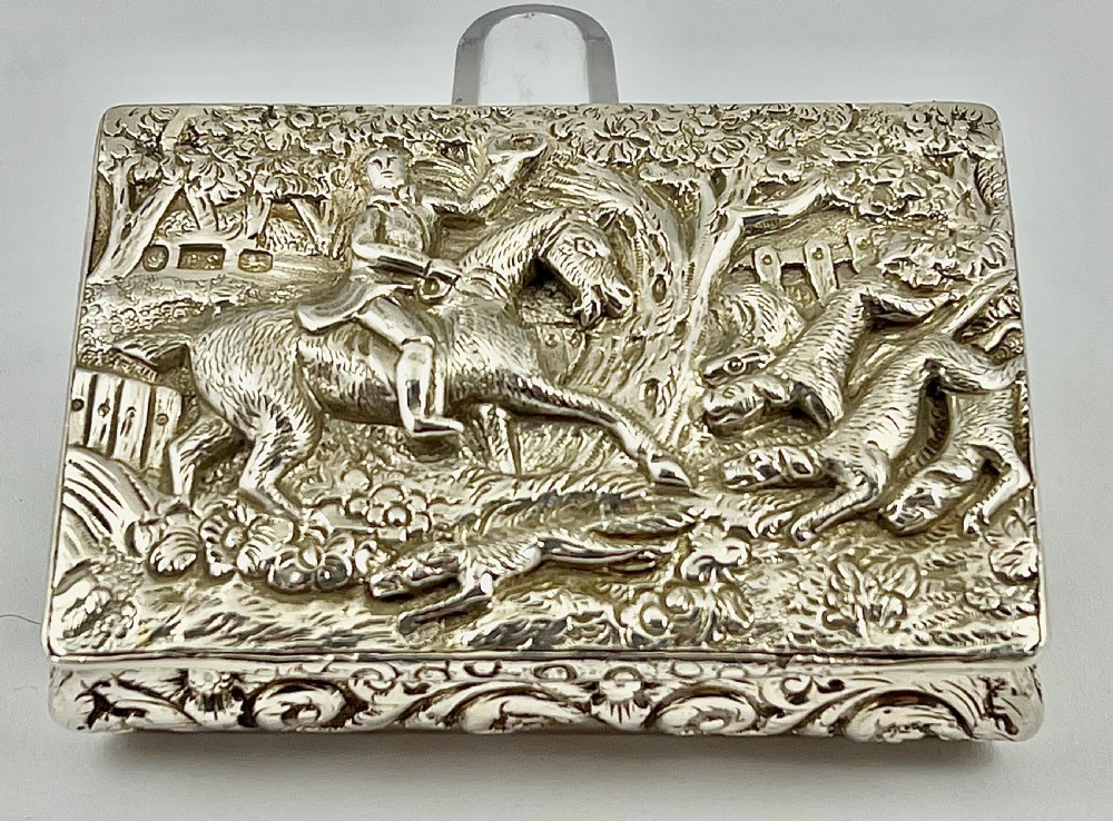 Rectangular sterling silver snuff box featuring a relief-carved hunting scene with a rider on horseback surrounded by hounds in a woodland setting. View XI