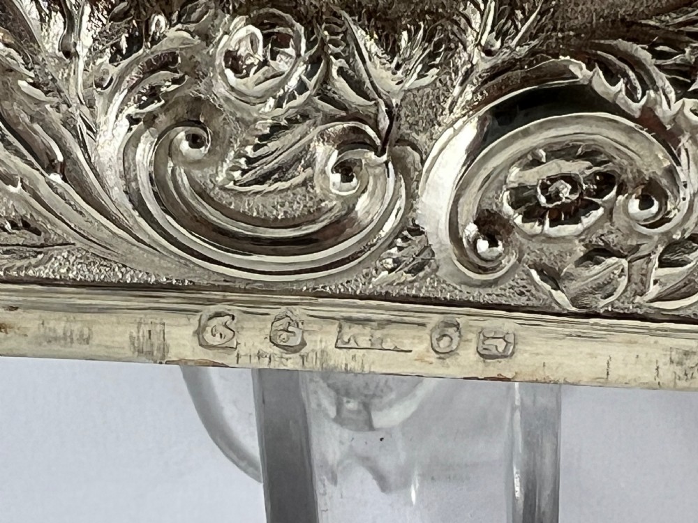 An Early Victorian sterling silver card case featuring detailed high-relief repousse carving of an architectural estate framed by scrollwork. View III