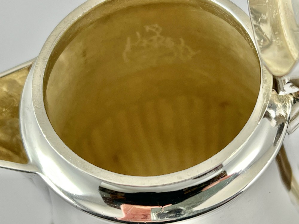 Victorian sterling silver hot water pot featuring a fluted lower body, hinged lid, and carved wooden handle. View VIII