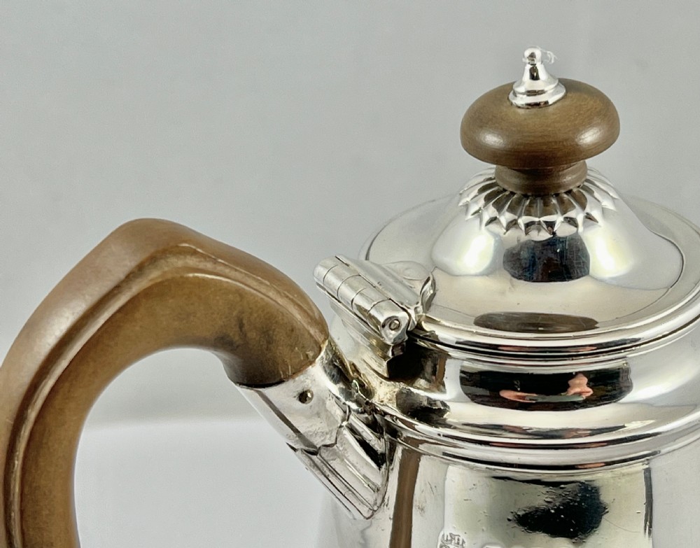 Victorian sterling silver hot water pot featuring a fluted lower body, hinged lid, and carved wooden handle. View XI