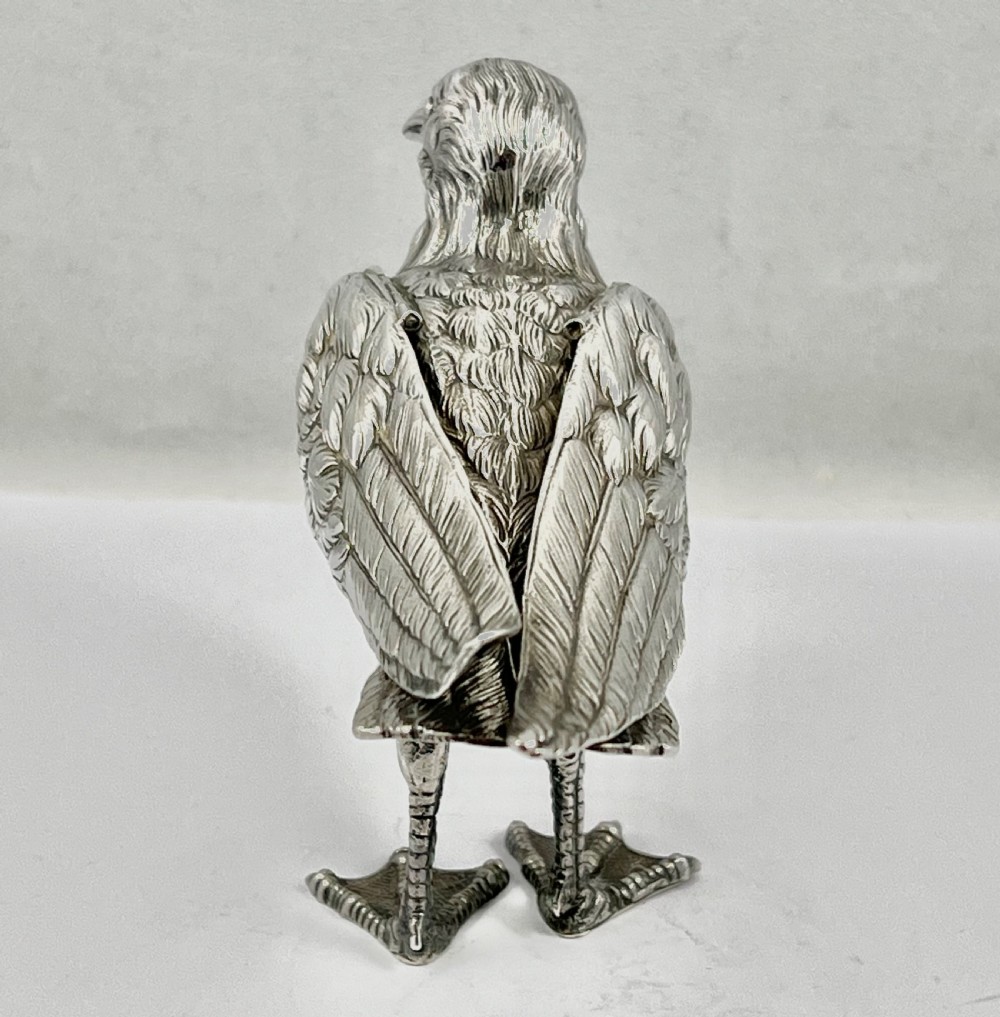 A chased Edwardian silver model of a wading bird with textured feather detail and webbed feet, shown in profile facing left. View VI
