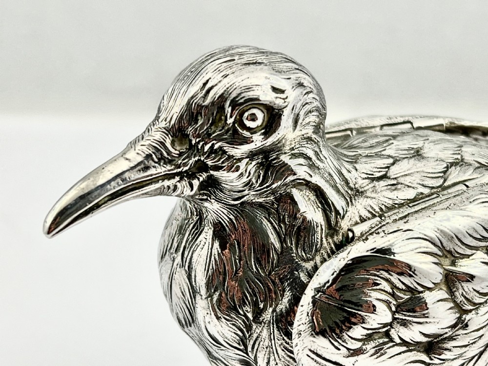 A chased Edwardian silver model of a wading bird with textured feather detail and webbed feet, shown in profile facing left. View VII