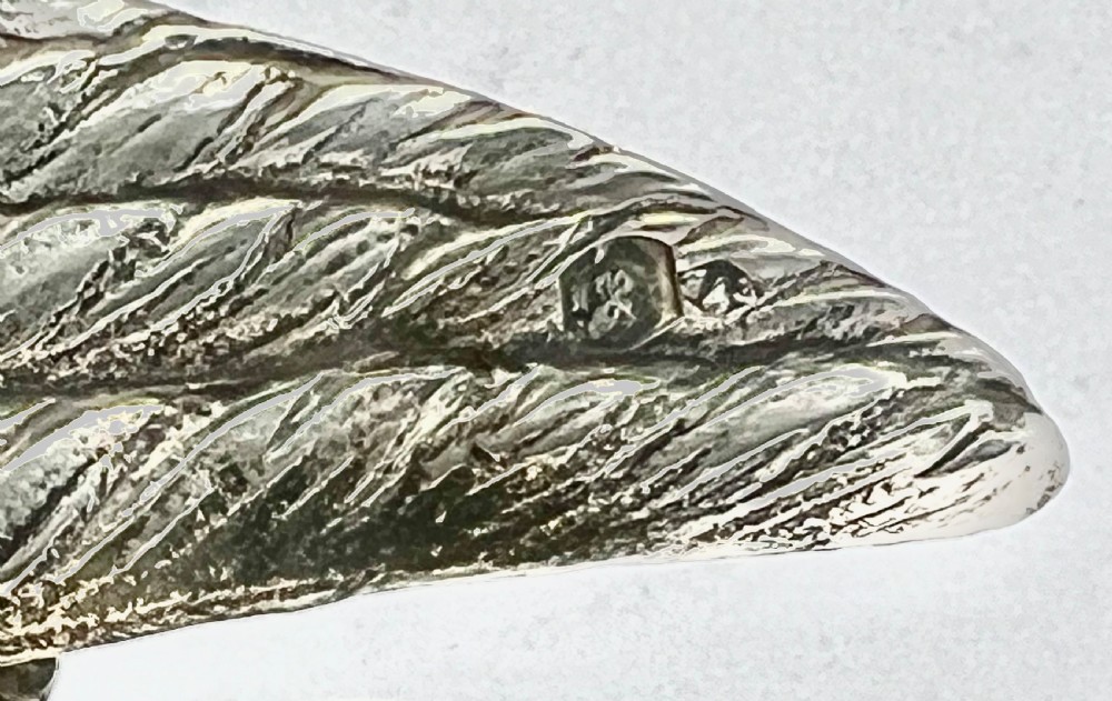 A chased Edwardian silver model of a wading bird with textured feather detail and webbed feet, shown in profile facing left. View VIII