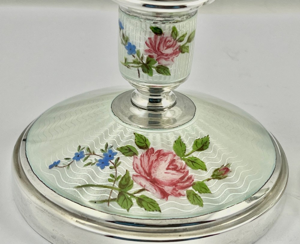 A pair of Elizabeth II sterling silver candlesticks featuring engine-turned white enamel bases and stems adorned with painted pink roses. View III