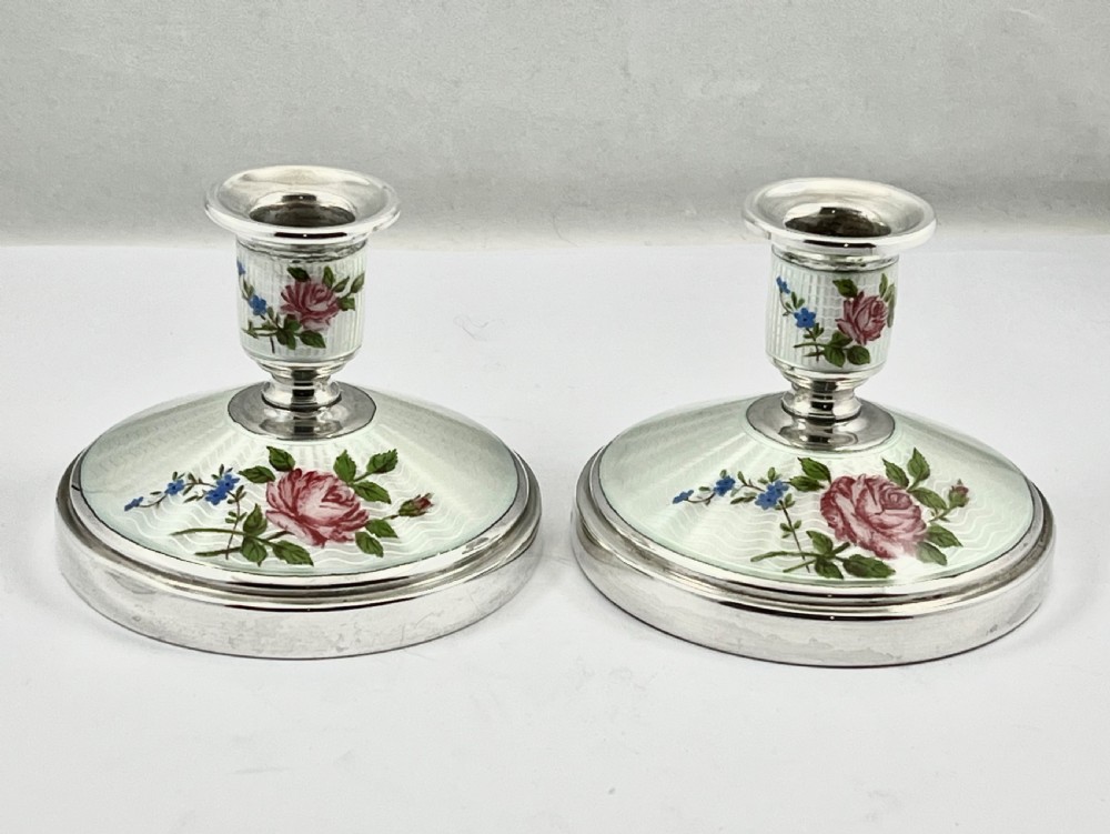 A pair of Elizabeth II sterling silver candlesticks featuring engine-turned white enamel bases and stems adorned with painted pink roses. View XI