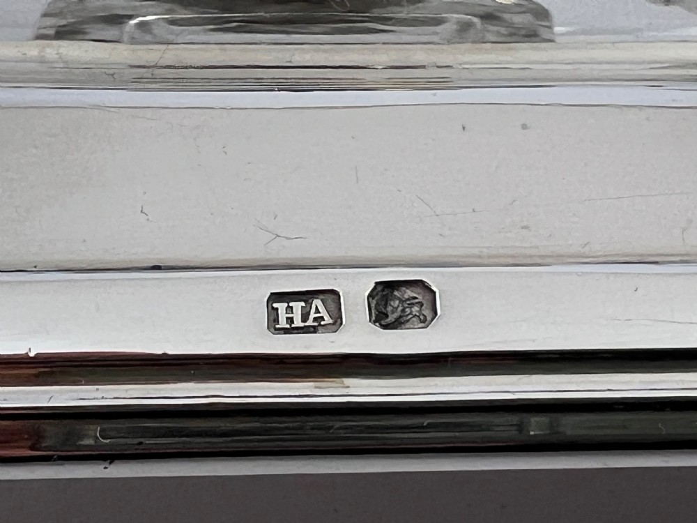 A late Victorian sterling silver inkstand set featuring two cut glass inkwells with silver caps, a central covered box, and a pen tray enclosed by a gallery rail. View XI