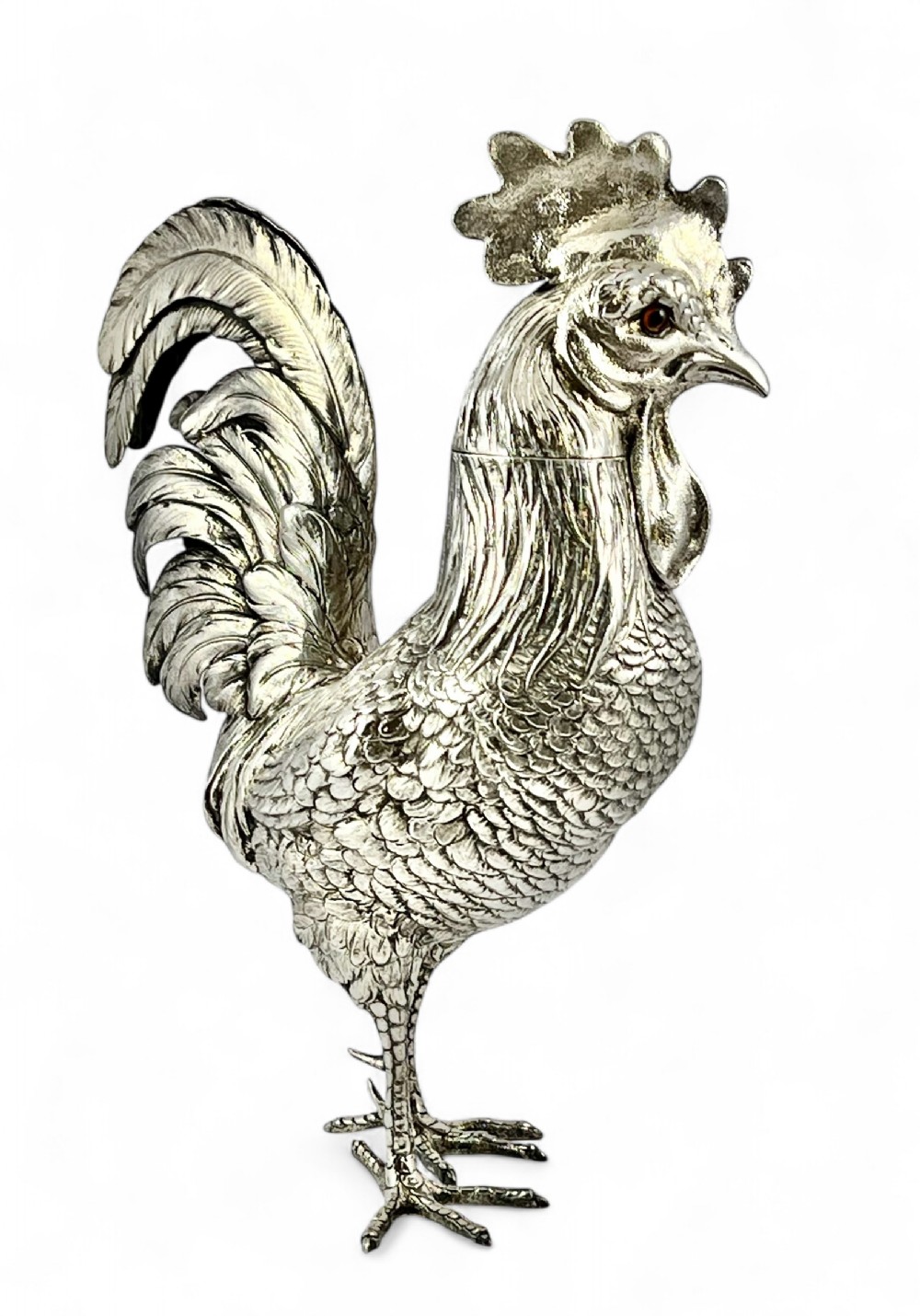A detailed silver statue of a standing cockerel with finely chased feathering, a pronounced comb, and red stone eyes.