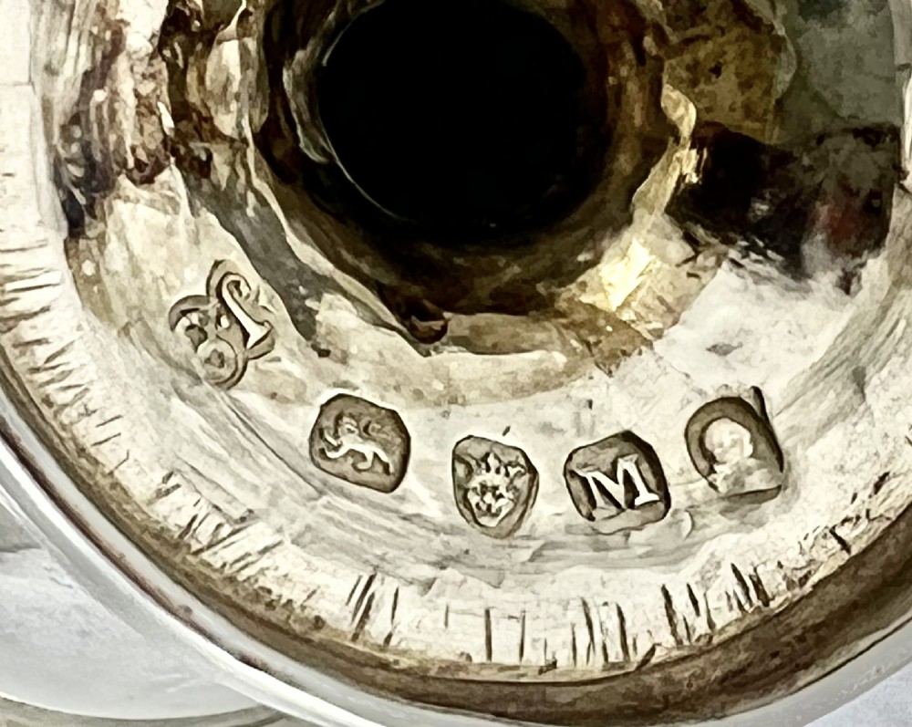 A George III sterling silver egg cruet set featuring a central handle, a gilt-lined salt cellar, six egg cups, and fitted silver spoons on a gadrooned stand. View XII