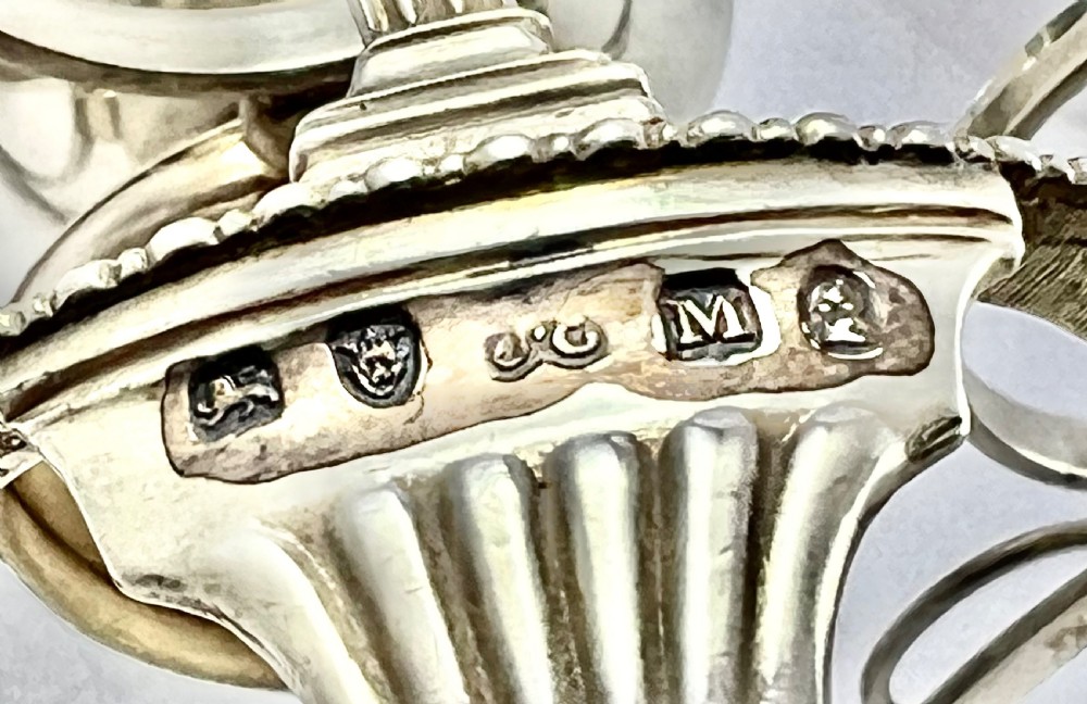 A George III sterling silver egg cruet set featuring a central handle, a gilt-lined salt cellar, six egg cups, and fitted silver spoons on a gadrooned stand. View XIII