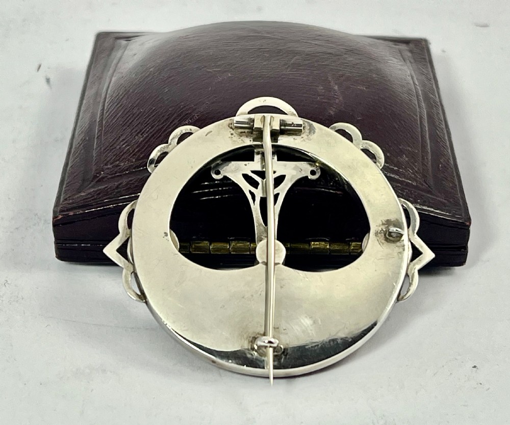 An early Victorian circular silver brooch inlaid with segmented polished Scottish agates and jaspers surrounding a central Celtic motif. View VI