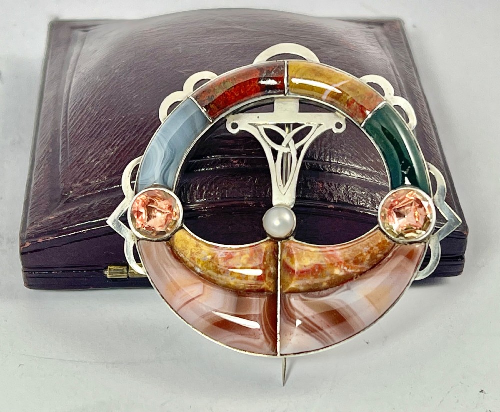 An early Victorian circular silver brooch inlaid with segmented polished Scottish agates and jaspers surrounding a central Celtic motif. View VII