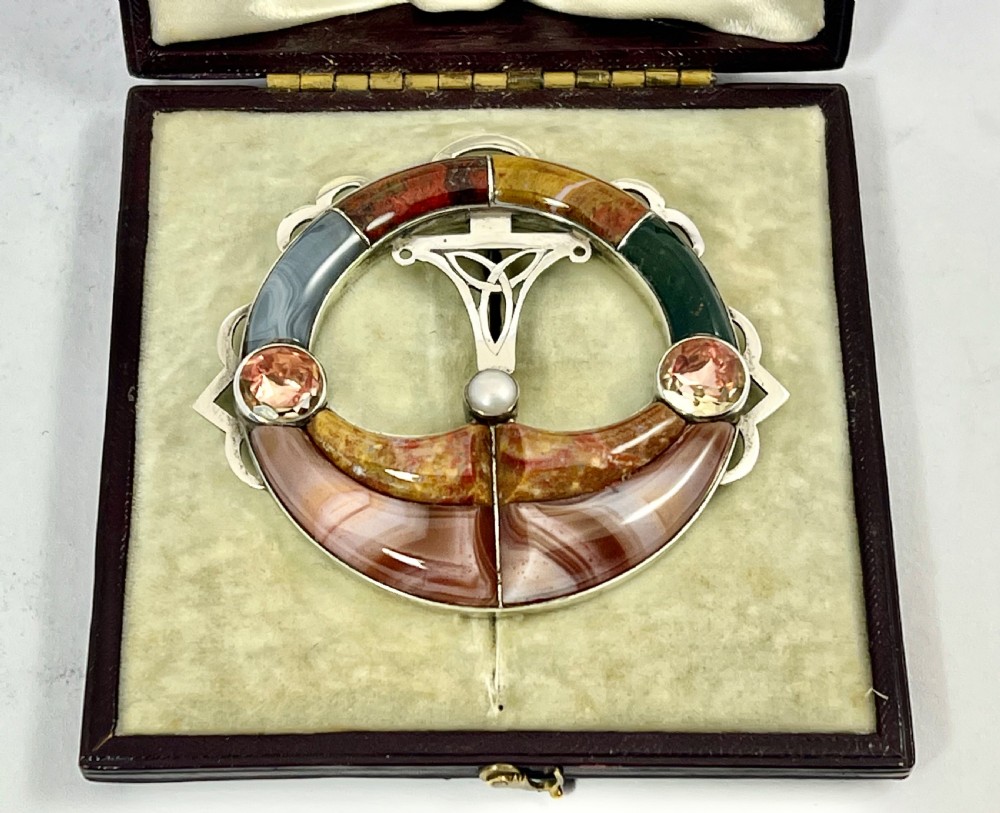An early Victorian circular silver brooch inlaid with segmented polished Scottish agates and jaspers surrounding a central Celtic motif. View VIII