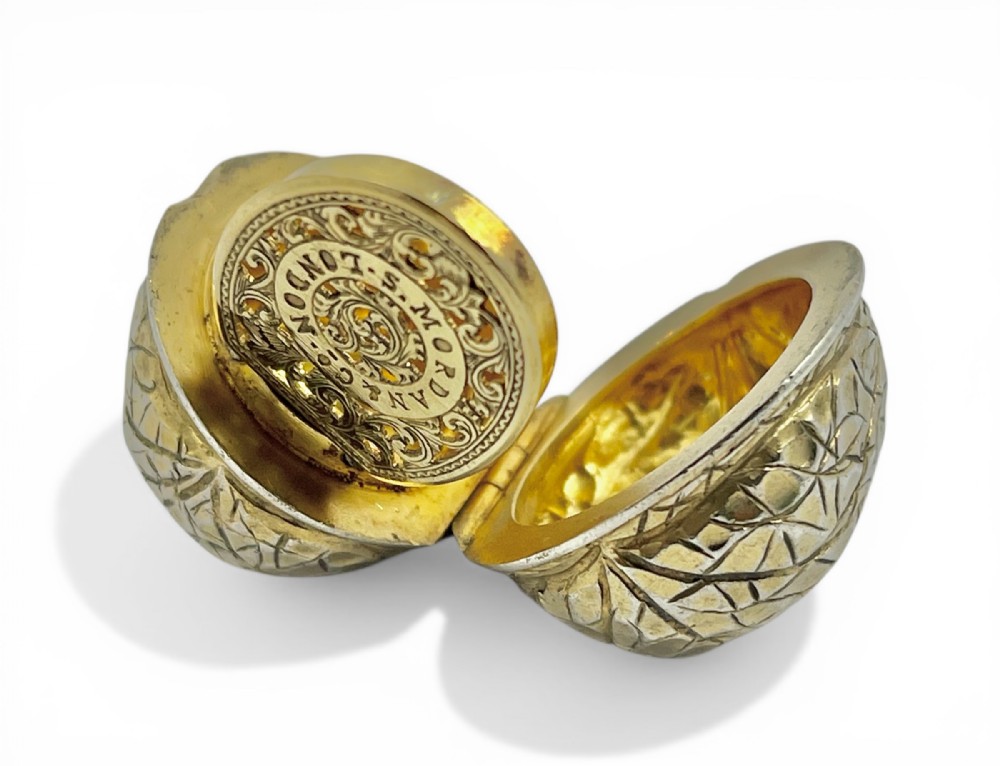 An opened Victorian silver gilt box formed as a textured walnut shell with a pierced internal grille stamped Samson Mordan London.