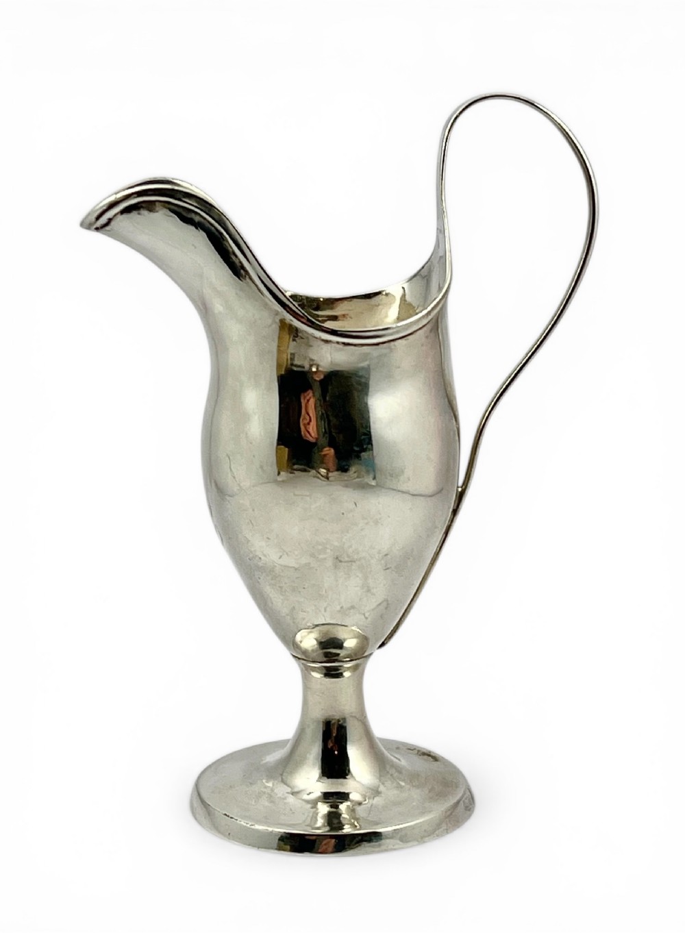 An 18th-century Scottish provincial silver cream jug featuring an elongated spout, high loop handle, and circular pedestal base.