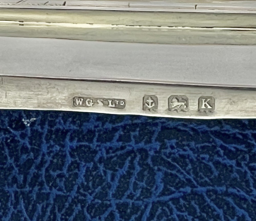 An Art Deco sterling silver jewellery box featuring a light blue guilloche enamel lid with white accents, a shaped body, and four small feet. View VIII