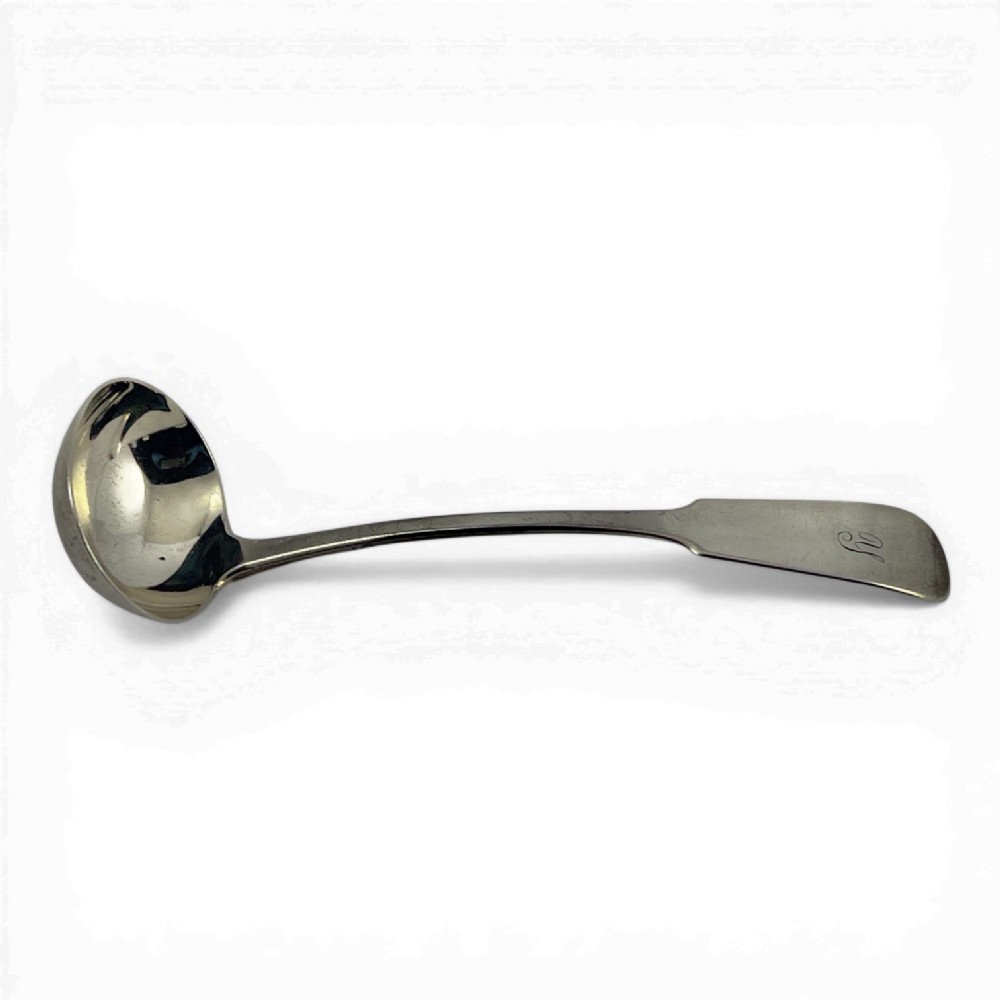 A Scottish provincial silver ladle featuring a deep circular bowl and a flat fiddle pattern handle engraved with a monogram.