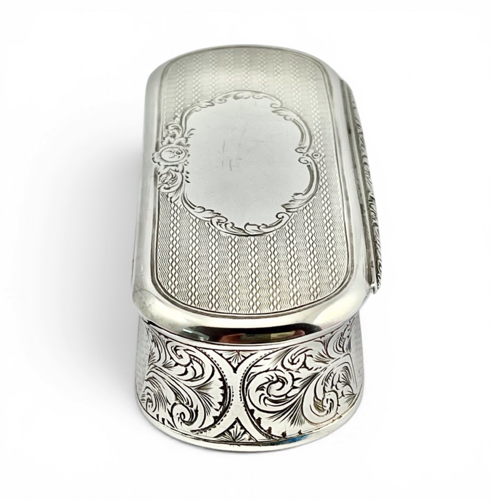 An antique Victorian sterling silver oblong table snuff box featuring engine-turned geometric engraving and an unengraved oval central cartouche on the hinged lid. View III