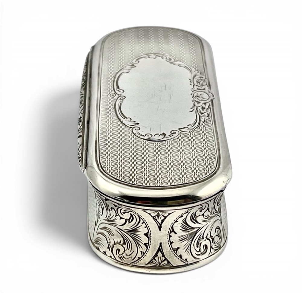 An antique Victorian sterling silver oblong table snuff box featuring engine-turned geometric engraving and an unengraved oval central cartouche on the hinged lid. View VII