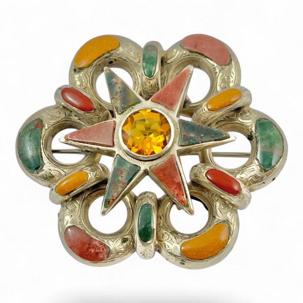 Victorian silver Scottish brooch with inlaid multicoloured agates surrounding a central star motif set with a faceted yellow citrine.