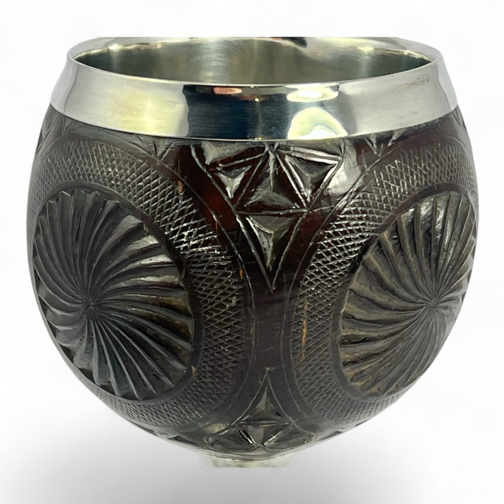 An eighteenth-century carved coconut shell goblet featuring intricate geometric starburst patterns, a silver rim, stem, and hallmarked circular base. View VI