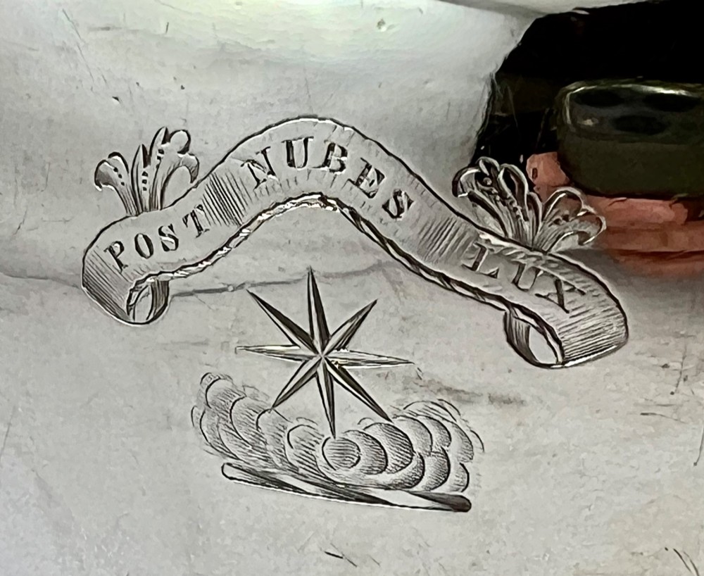 A William IV sterling silver water jug featuring a hinged domed lid, acanthus leaf relief carving, engraved monogram, and an angular insulated handle. View X