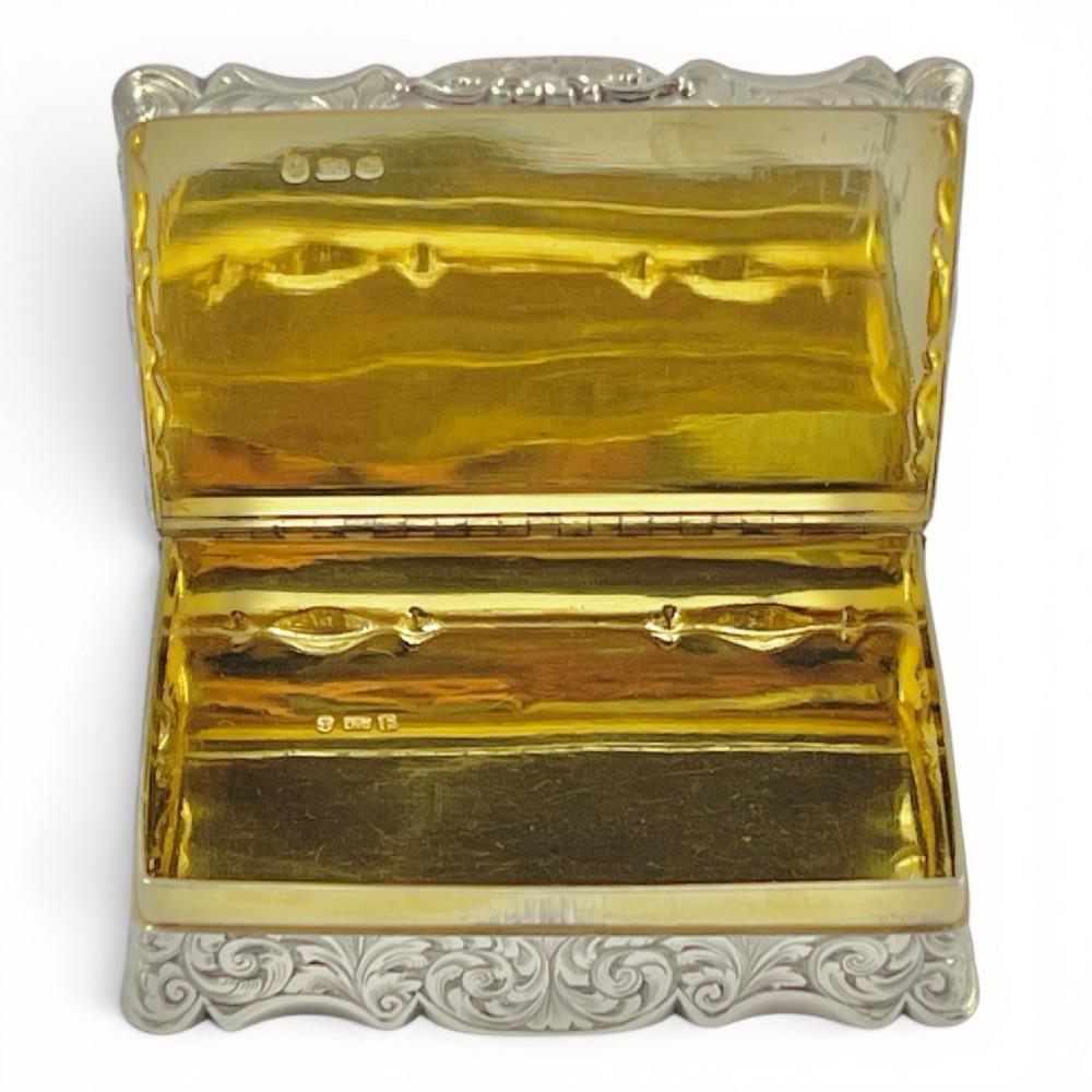 An early Victorian sterling silver table snuff box decorated with elaborate foliate engraving and a central equestrian scene of two jockeys riding horses. View VII