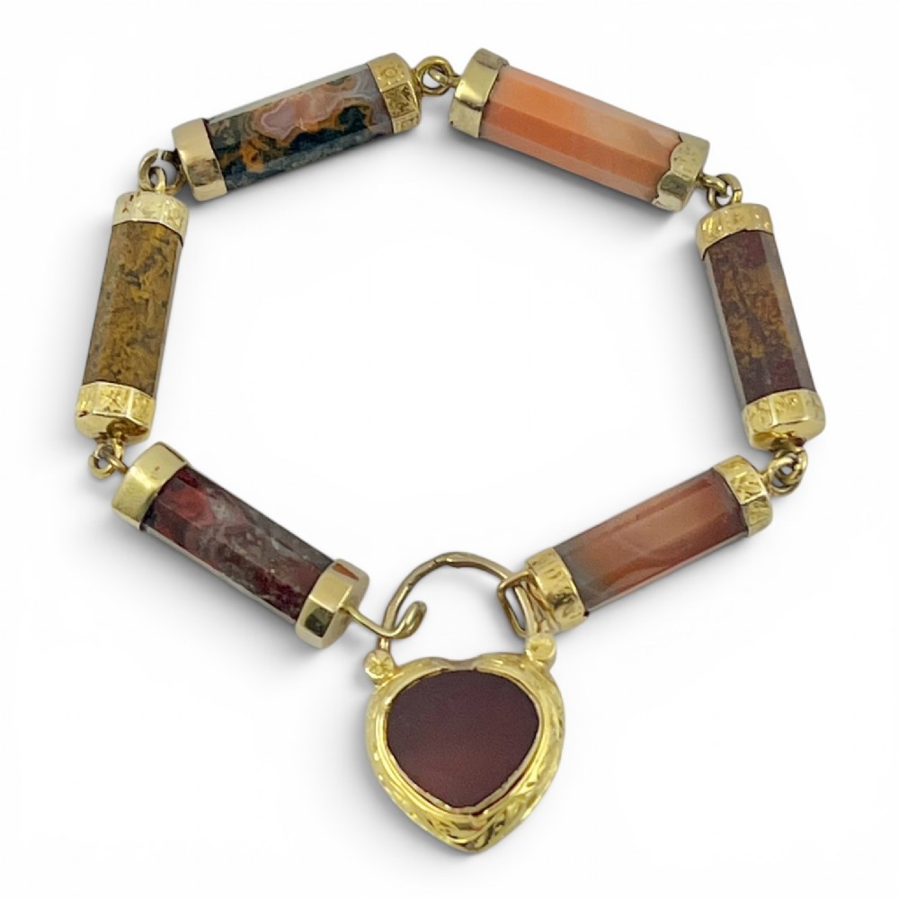 A Victorian 9ct gold bracelet featuring cylindrical faceted agate stone links connected by gold bands and an engraved heart padlock clasp. View II