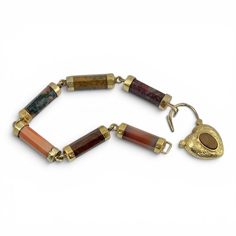 A Victorian 9ct gold bracelet featuring cylindrical faceted agate stone links connected by gold bands and an engraved heart padlock clasp. View V