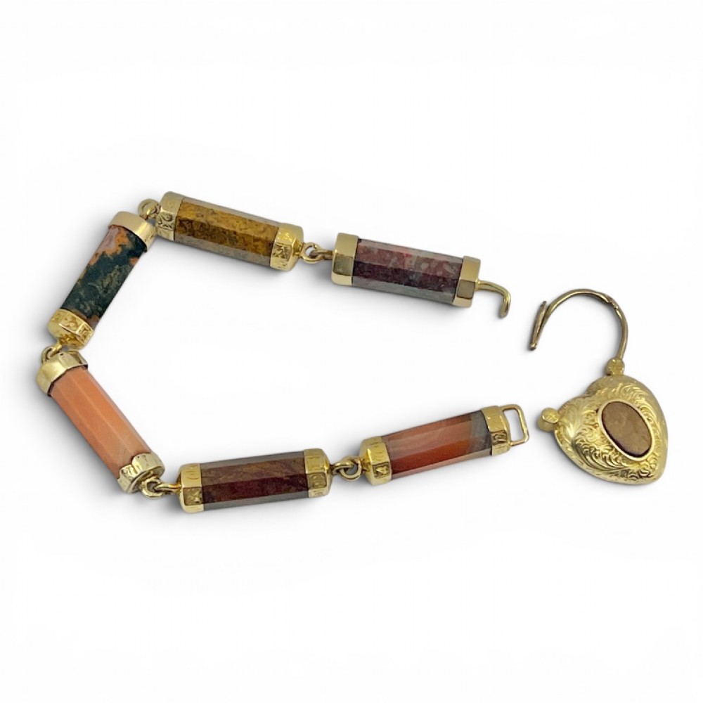 A Victorian 9ct gold bracelet featuring cylindrical faceted agate stone links connected by gold bands and an engraved heart padlock clasp. View VI