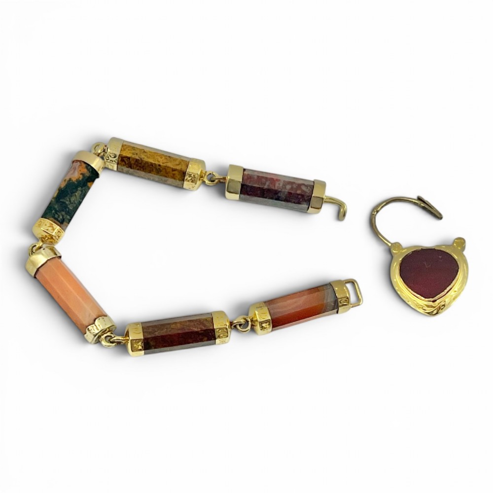 A Victorian 9ct gold bracelet featuring cylindrical faceted agate stone links connected by gold bands and an engraved heart padlock clasp. View VII