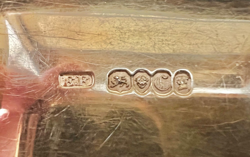 A rectangular Victorian sterling silver snuff box featuring high-relief floral border carving, engine-turned sides, and an engraved inscription on the central lid. View X