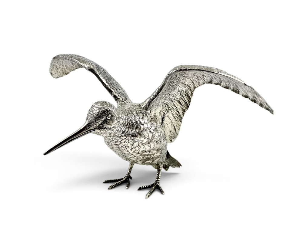 A late Victorian sterling silver figure of a woodcock bird with outstretched wings and detailed hand-chased plumage.