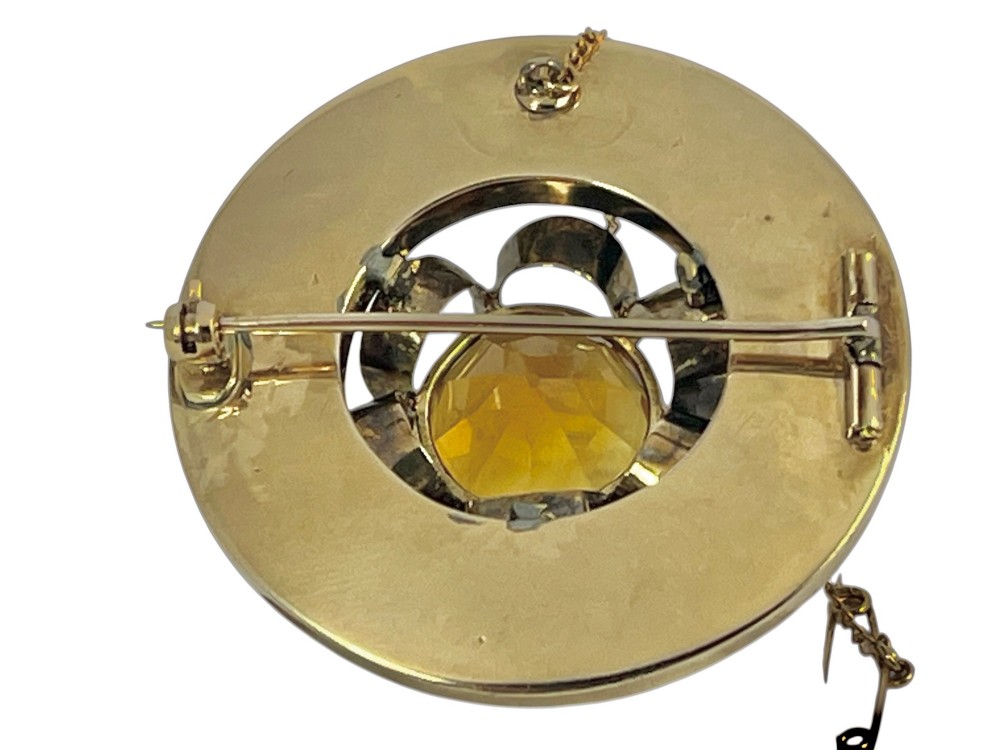 A circular Victorian 18ct gold brooch set with a central faceted yellow citrine gemstone surrounded by wedge-shaped inlaid agate and bloodstone panels, fitted with a safety chain. View IV