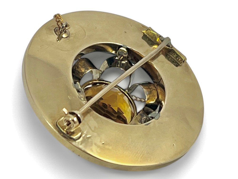 A circular Victorian 18ct gold brooch set with a central faceted yellow citrine gemstone surrounded by wedge-shaped inlaid agate and bloodstone panels, fitted with a safety chain. View V