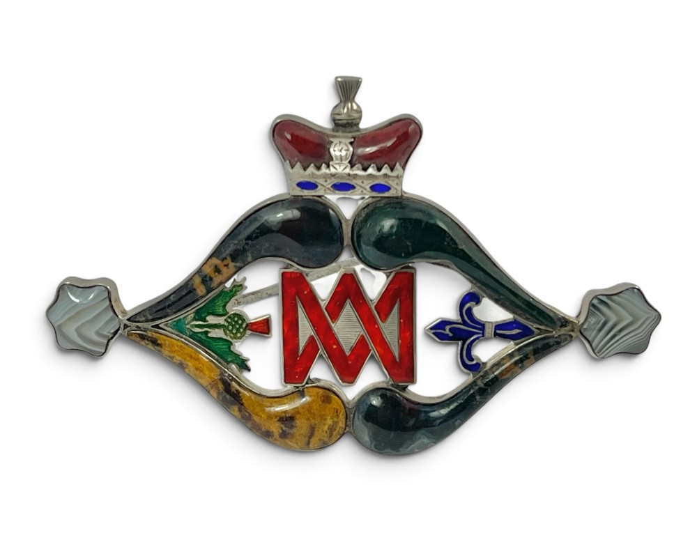 A late Victorian Scottish silver brooch inset with multi-coloured agates, red enamel monogram, blue enamel fleur-de-lis, and a crown detail.