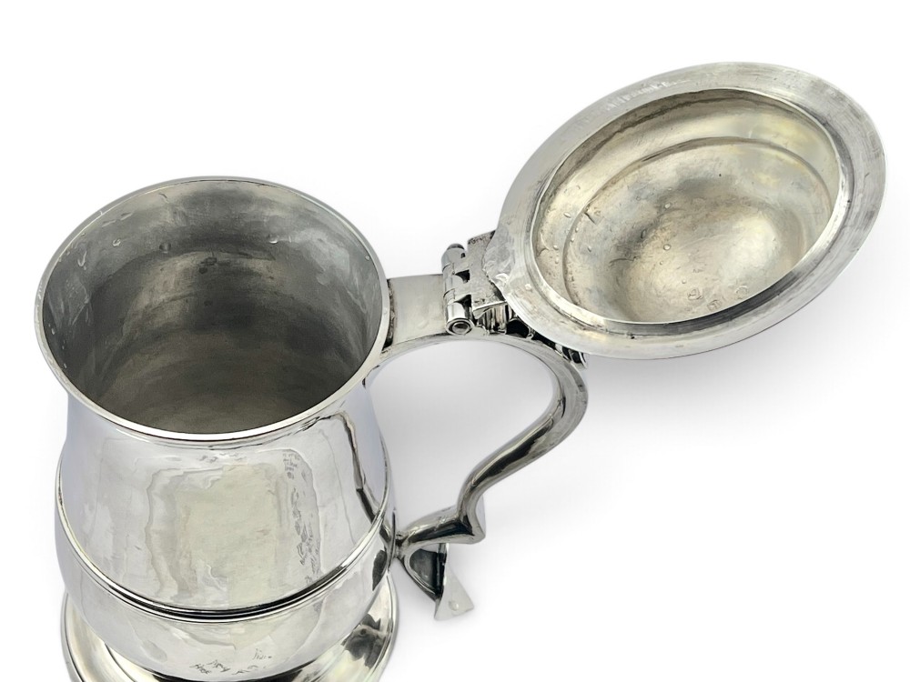 A George III sterling silver lidded tankard featuring a tapered body with a central mid-rib, a hinged domed lid, a pierced thumbpiece, and a double-scroll handle. View III