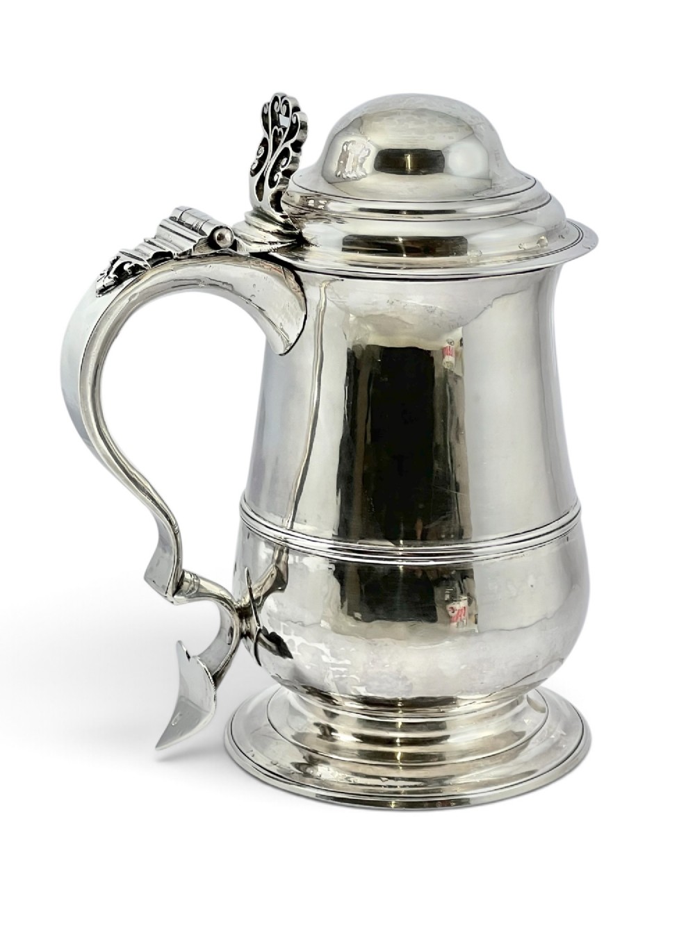A George III sterling silver lidded tankard featuring a tapered body with a central mid-rib, a hinged domed lid, a pierced thumbpiece, and a double-scroll handle. View VII