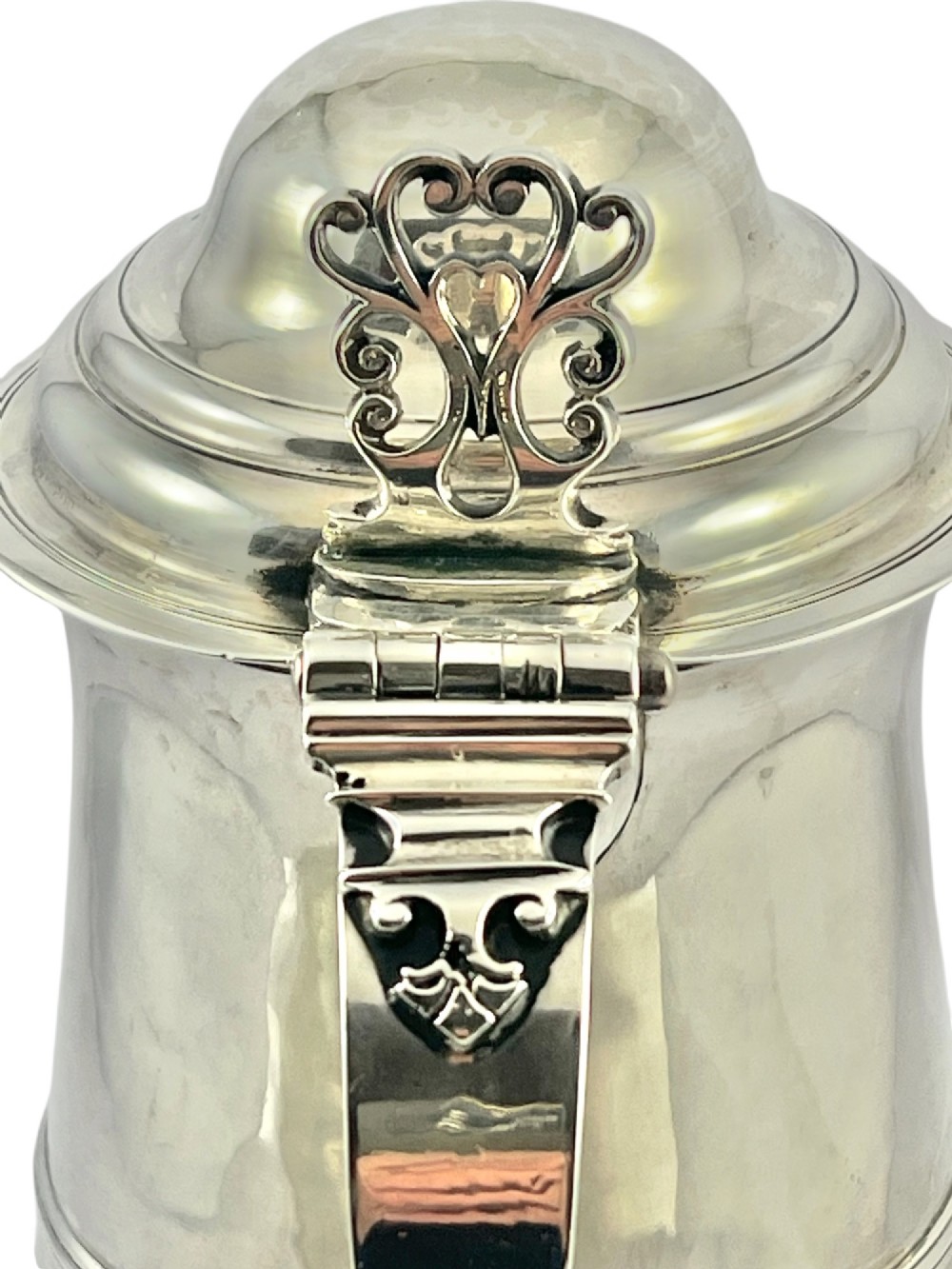 A George III sterling silver lidded tankard featuring a tapered body with a central mid-rib, a hinged domed lid, a pierced thumbpiece, and a double-scroll handle. View VIII
