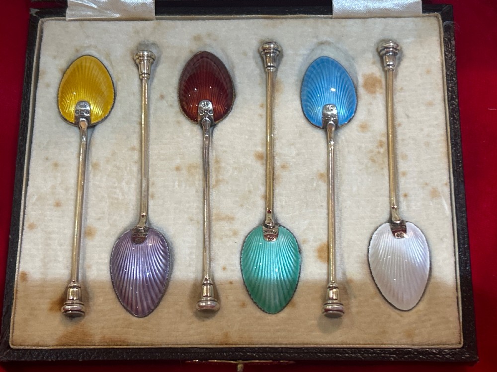 A cased set of six silver spoons featuring vibrant, colourful guilloche enamel bowls housed inside a satin-lined fitted presentation box. View IV