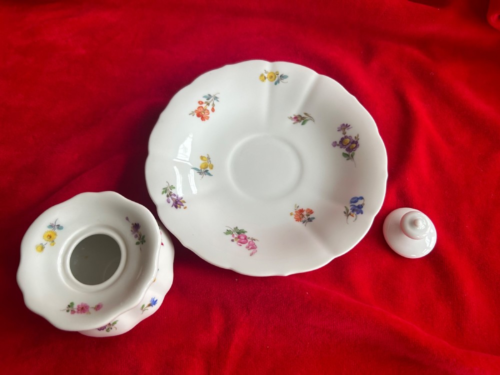 A white Meissen porcelain inkwell featuring hand-painted floral sprigs, a scalloped base plate, fluted inkwell body, and fitted porcelain lid with finial. View IV