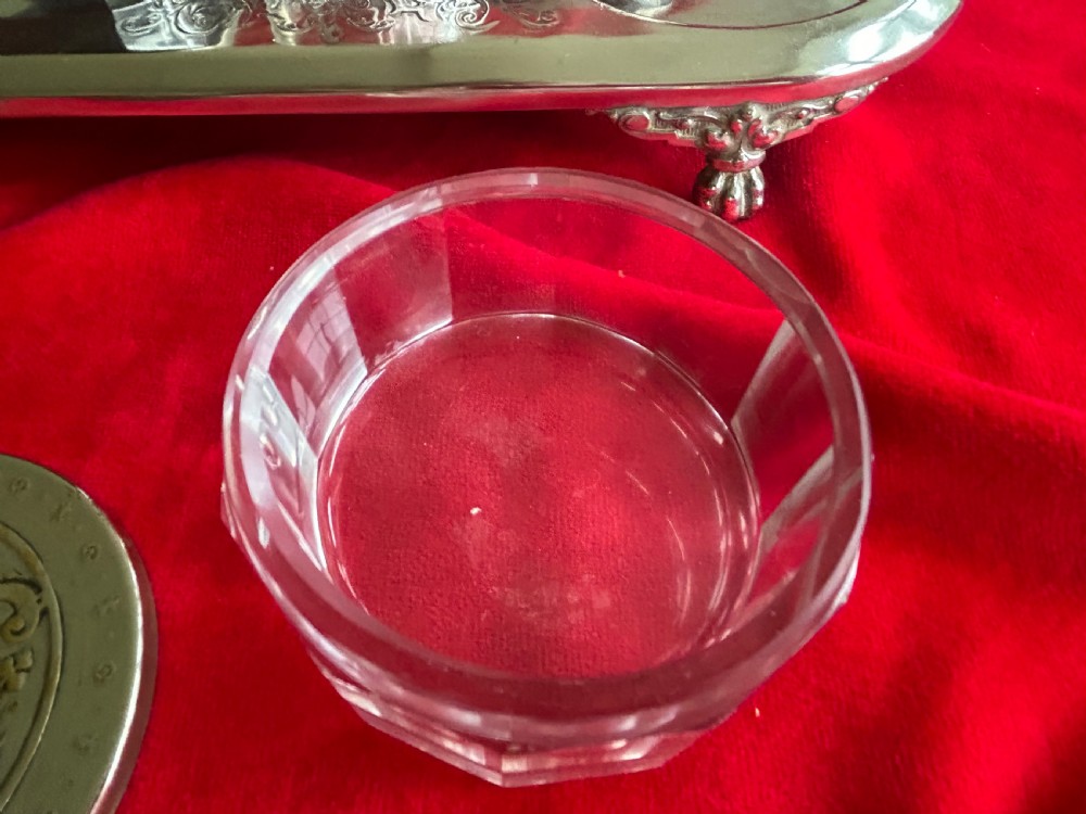 A tiered silver-plated metal stand by WMF holding four clear cut-glass pots with relief-patterned lids resting on ornate feet. View VI