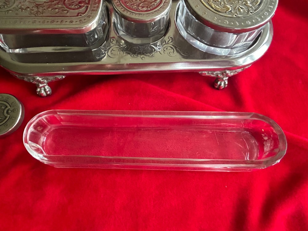 A tiered silver-plated metal stand by WMF holding four clear cut-glass pots with relief-patterned lids resting on ornate feet. View VIII