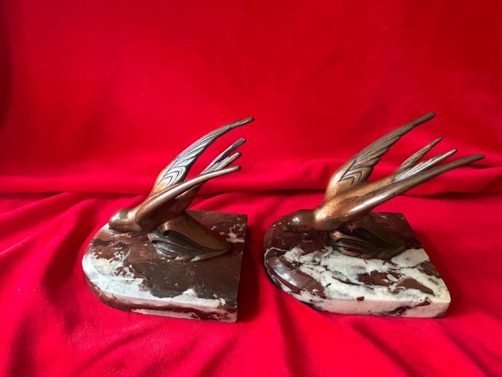 A pair of French Art Deco bronze swallow bookends mounted on polished reddish-brown veined marble bases. View II